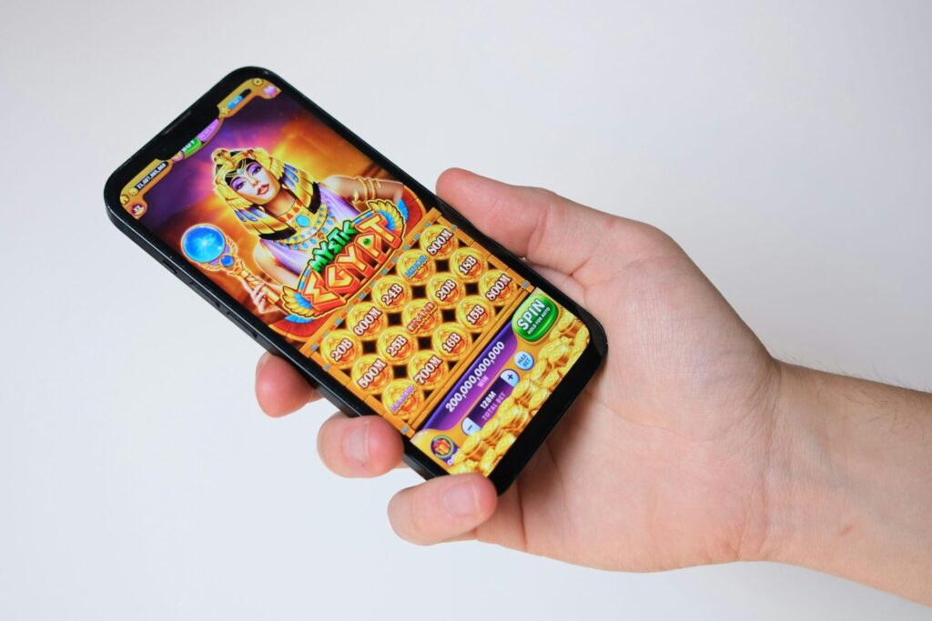 giocare d'azzardo online: rischio ludopatia. Una mano sorregge uno smartphone con un'applicazione di gioco avviata. 